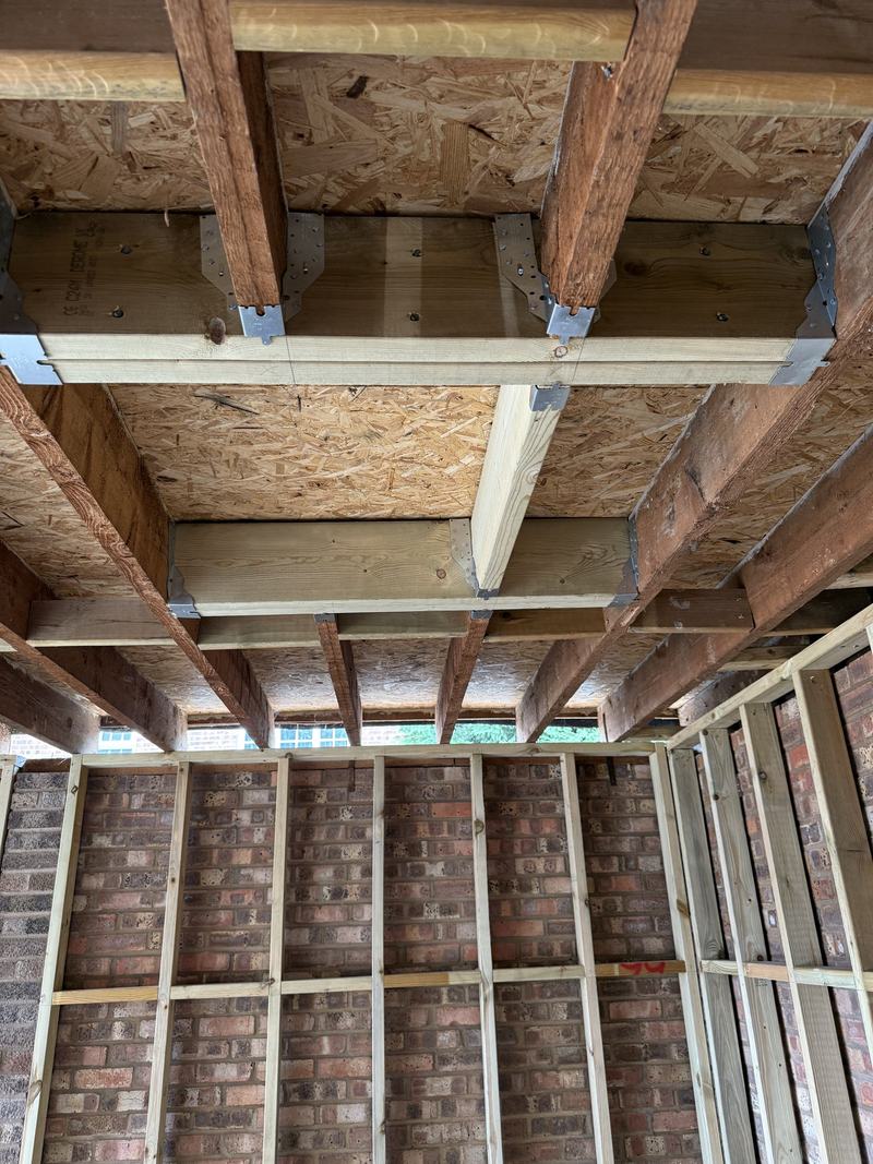 Structure: Roof joists and wall battens over the existing brickwork.