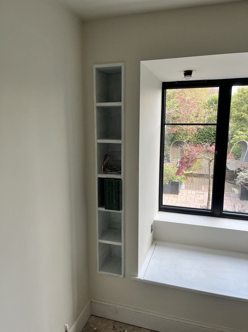 Window seat: The seat and slim niche shelving fitted into the bay.